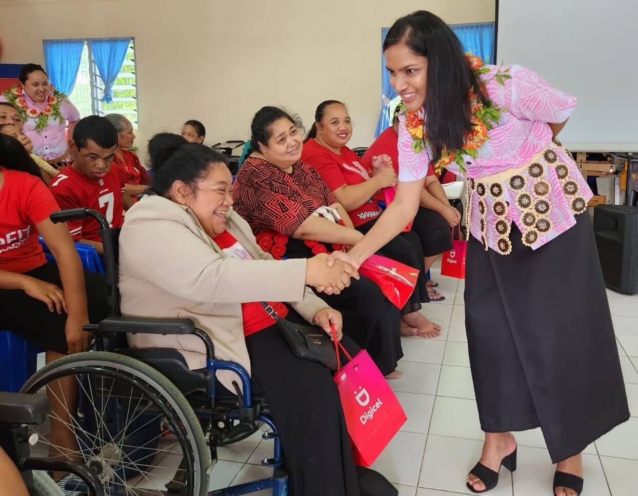 Digicel Pacific Regional CEO Shally Jannif shaking hands with a resident of the Mango Tree Center