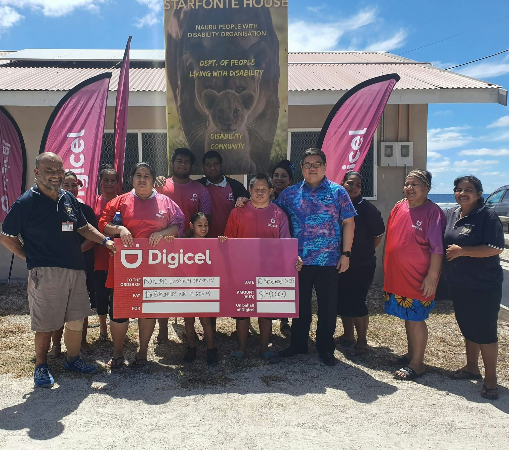 A group of staff from the Department of People Living with Disability staff and Digicel holding a check for $130,000 AUD